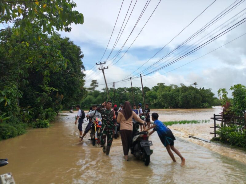 Babinsa Koramil 2215/Ciemas Bantu Warga Melintasi Jalan dan Jembatan Tergenang Banjir 5