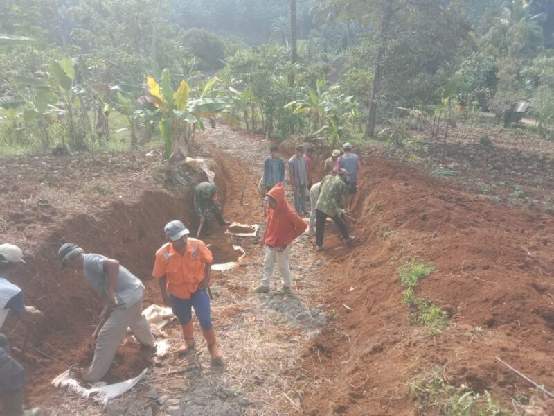Babinsa Koramil 2204/Cikidang Laksanakan Bhakti Pelebaran Jalan Desa
