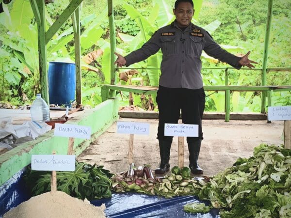 Person surrounded by various vegetables.